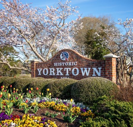 Brick sign in a lush garden saying "Historic Yorktown"