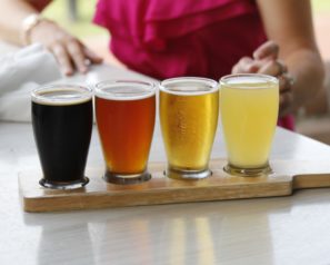 A flight of 4 beers, from very dark to amber to golden to pale.