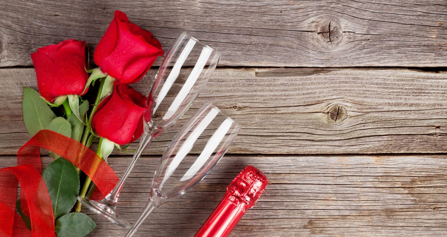 Roses and champagne glasses on wood slats