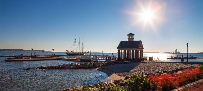 Beach with a gazebo and old time sailing ship in the background
