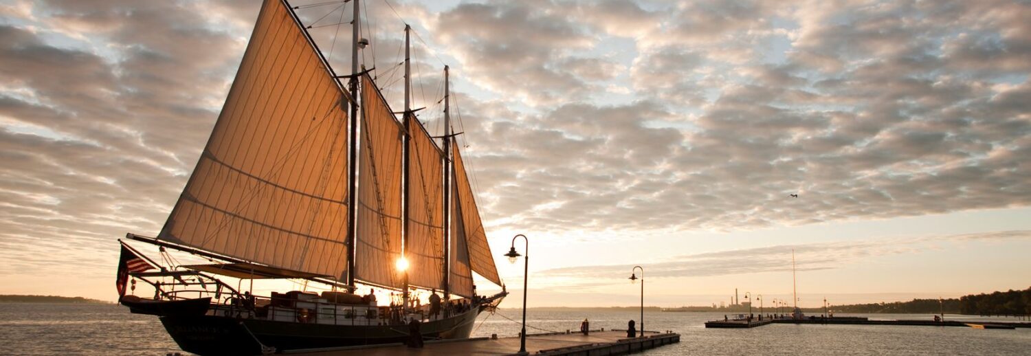 Wide view of a ship in the Yorktown River as the sun is setting near Yorktown Beach Hotel.