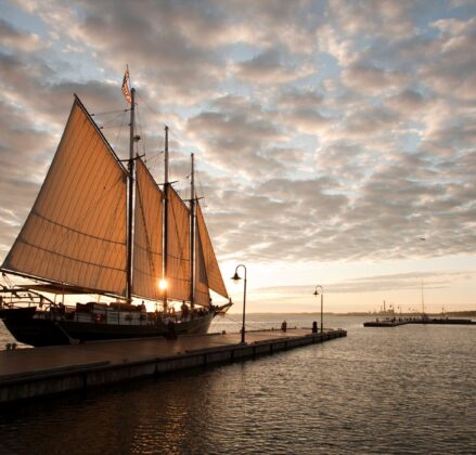 Wide view of a ship in the Yorktown River as the sun is setting near Yorktown Beach Hotel.